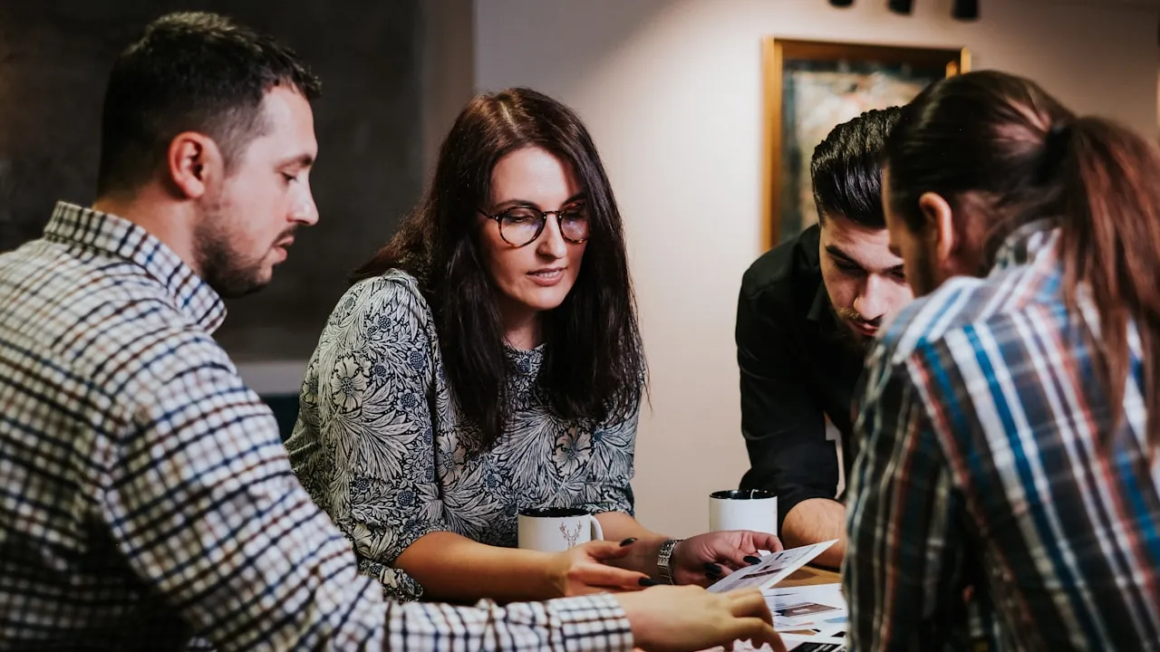 Grupo reunido em sala analisando resultados de assembleia de consórcio