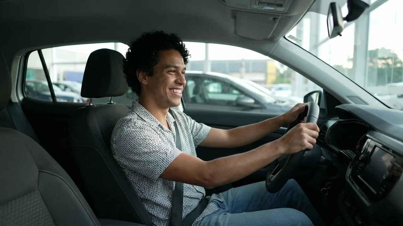 Jovem brasileiro dentro do hatch novo conquistado por consórcio sem juros