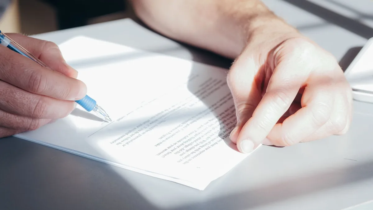 Pessoa lendo atentamente um contrato antes de assinar