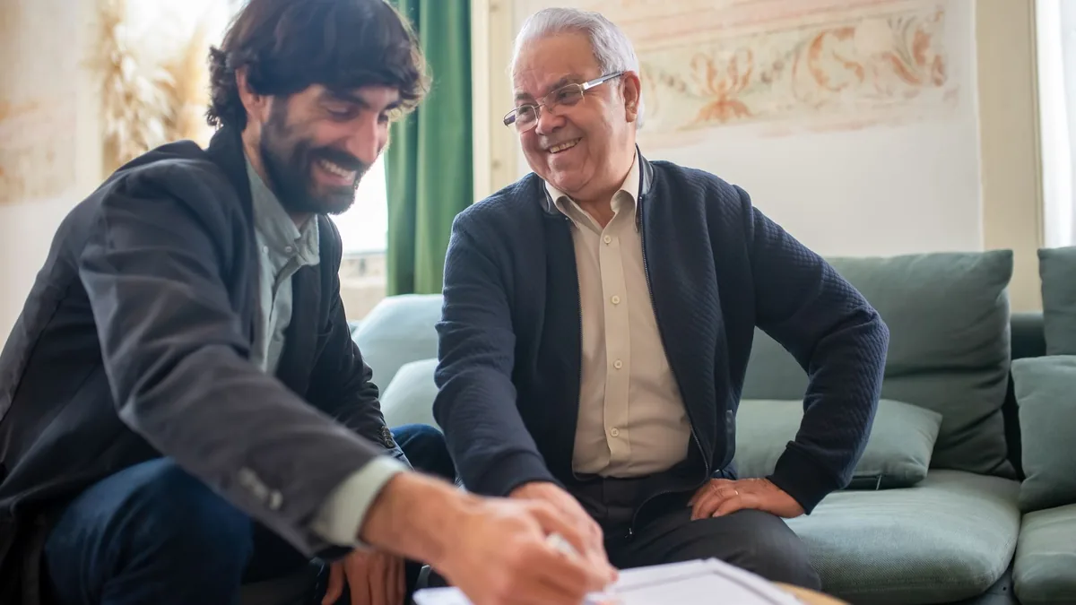 Duas pessoas conversando sobre planejamento financeiro com documentos